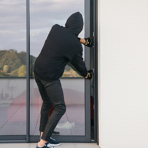 Burglar trying to break into a house