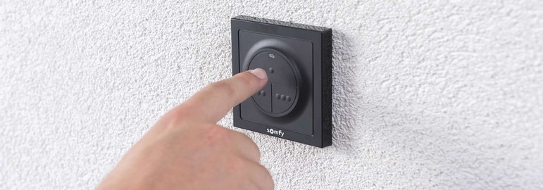 somfy-hand-on-wall-switch-home
